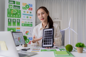 Asian business professional woman presents sustainable energy solutions green business strategies...