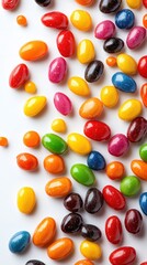 Colorful candy assortment scattered on a white surface, showcasing vibrant shapes and textures in bright daylight