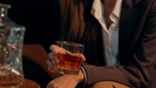  Closeup business woman holding a glass of whiskey
