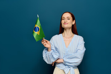 Language teacher with red hair proudly holding a Brazilian flag in a creative studio