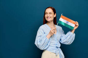 Language teacher with red hair proudly holding a flag in a bright studio