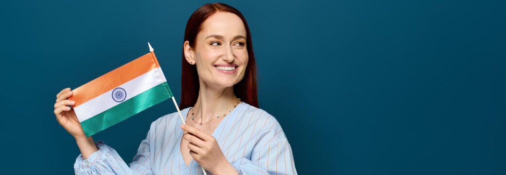 Language teacher with red hair proudly displays flag in a bright studio setting - Powered by Adobe