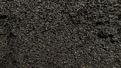 close-up of black textured surface with intricate patterns and porous structure ideal for abstract backgrounds and commercial designs