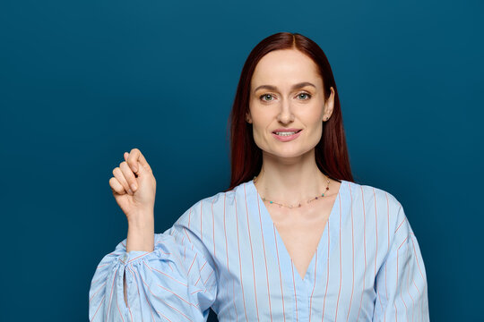 Red-haired teacher conducts sign language lessons for students against a blue backdrop