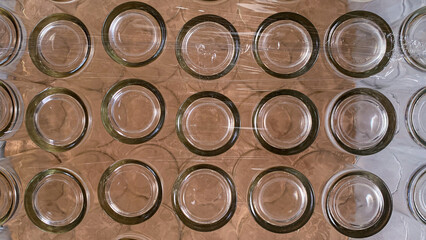 Top view of empty glass jars neatly arranged in packaging, transparent containers perfect for storage, food preservation, crafts, and kitchen organization.