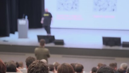 Presentation during a professional event. Interactive session with attendee engaging speaker.