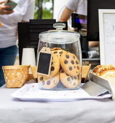 A close-up of a jar of oatmeal cookies and chocolate chips. A jar of sweets at a children's party.