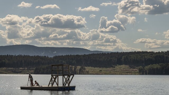 Children playing on a platform at a bathing place at Lake Mj&oslash;sa or Mjosa with wooded shore, Olavsweg or Olavsleden, near Tangen, Norway