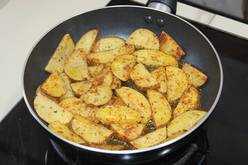 Golden Crispy Potato Wedges Frying in Pan