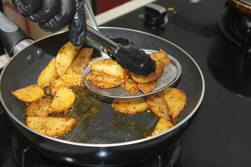 Chef Frying Crispy Potato Wedges in Pan