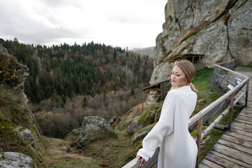 Beautiful girl standing on top of rocks in autumn