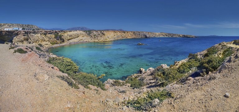Quiet coastal bay Paralia Agios Theodoros with clear water and a blue sky over the rocky landscape, Arkasa, Karpathos, Greece