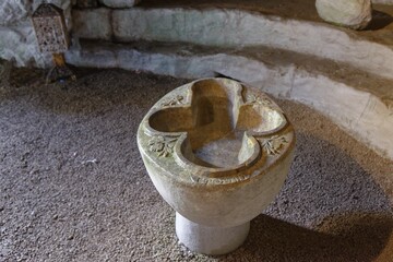 Artfully engraved stone baptismal font in the ancient style of the cave church of St John Vrykountas, cave church of St John Vrykountas, Avlona, Karpathos, Greece