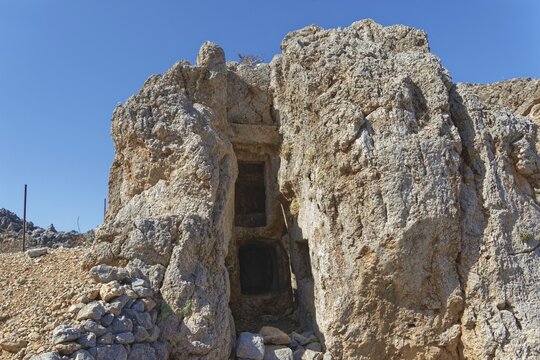 Entrance to a pantry carved into the rock of the ancient Dorian city of Vrougounda, Avlona, Karpathos, Greece