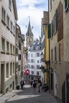 Narrow alley in the old town of Zurich, behind the tower of the historic parish church of St Peter, old town, Zurich, Switzerland