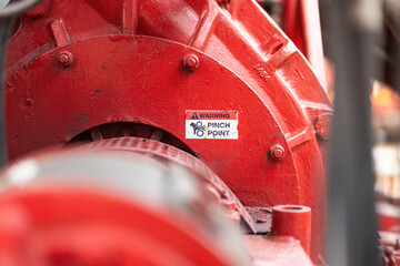 "Pinch point warning sign" hand and finger injury prevention alert that showed on the industrial equipment such as blender, pumping or milling machine. Safety sign in unsafe working place, close-up.