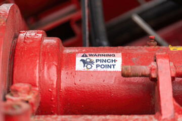 "Pinch point warning sign" hand and finger injury prevention alert that showed on the industrial equipment such as blender, pumping or milling machine. Safety sign in unsafe working place, close-up.
