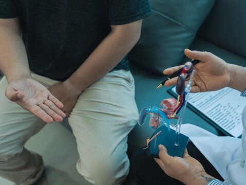A young man goes to the doctor to be checked for a urinary tract infection and an enlarged prostate. The doctor advises him about symptoms such as frequent urination. Close-up photo.