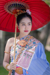 Pretty Asian Thai woman wearing traditional Thai dress costumes according to Thai culture at the ancient temple in famous tourist attraction in Thailand.