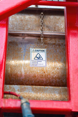 "Pinch point warning sign" hand and finger injury prevention alert that showed on the industrial equipment such as blender, pumping or milling machine. Safety sign in unsafe working place, close-up.