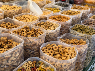 Traditional italian snack Taralli crackers from Apulia region with different flavours in plastic bags on a local market