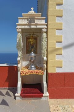 A decorative shrine in front of the church of Panagia Vrisiani on the coast with the blue sea in the background, in a Mediterranean setting, Mesochori, Karpathos, South Aegean, Greece