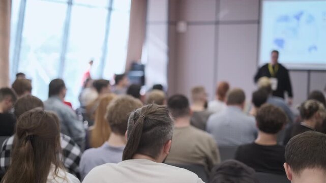 Conference setting with attendees seated, engaging in a speaker presentation on professional topics.