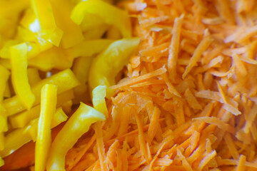Brightly colored bell peppers and grated carrots arranged for a fresh salad preparation