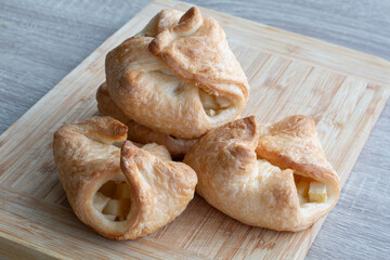 Fresh homemade puff pastries with apple filling on wooden board