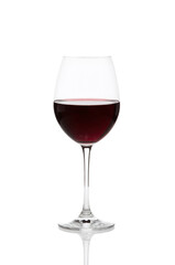 A glass of deep red wine sits elegantly on a reflective surface against a clean white background, capturing the essence of a refined beverage