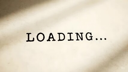 Conceptual image of waiting and progress featuring the word LOADING... in a vintage typewriter font on textured beige paper