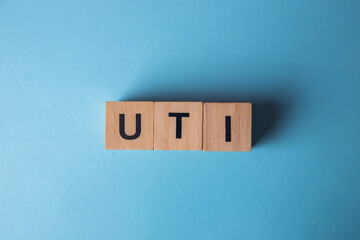 Uti acronym on wooden blocks with blue background