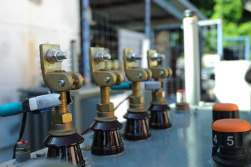 Close-up view of the upper part of a power distribution transformer with connectors and ceramic...