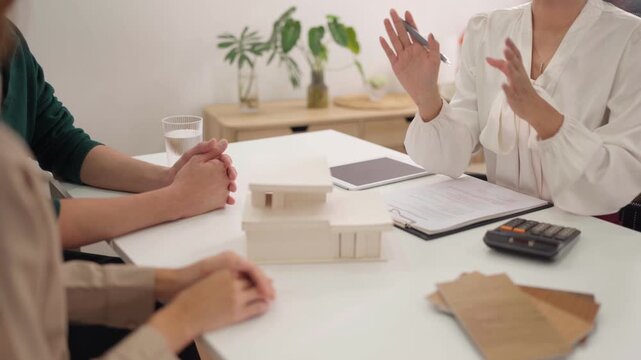 Asian adult couple signs real estate contract with expert agent finalizing property investment deal during significant home ownership consultation meeting