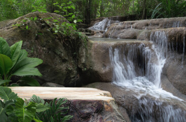 wood stump table top podium with outdoor waterfall tropical forest nature background landscape.Natural water mineral product present placement pedestal wooden stand display.jungle paradise concept.