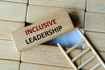 Inclusive leadership text written on wooden blocks placed on top of a ladder representing team growth and empowerment.