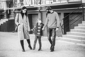 COVID-19. Mom dad and sat down went for a walk in worn masks. Family wearing medical mask. Black and white