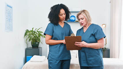 Physiotherapist And Senior Clinician Discuss Treatment Plan During Clinic Visit And Team Collaboration