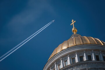 Golden dome, airplane contrail, vibrant blue sky