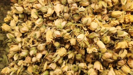 A mixture of dried herbs and flowers, possibly for tea preparation. It features predominantly purple and green hues. The purple likely consists of dried petals or leaves, while the green components in