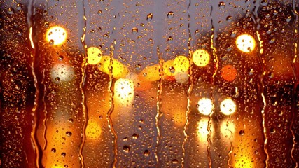 Raindrops and streaks on a window with glowing city bokeh at dusk; warm amber and yellow lights create a moody urban night atmosphere. - Powered by Adobe