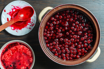 Delicious cherry jam in a saucepan on a wooden table, closeup, top view. Summer preparation and preservation of berries for the winter, home cooking