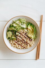 Cold ramen salad bowl with cucumbers, lettuce, avocado slices, and sesame dressing in pastel bowl