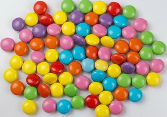 Fototapeta premium Vibrant, colorful candy assortment scattered on a clean white background, creating a playful and appealing visual.