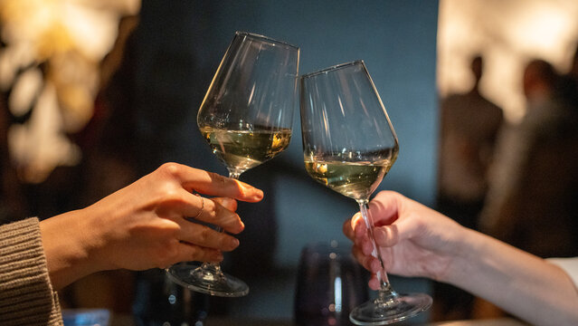 hands with glasses of wine