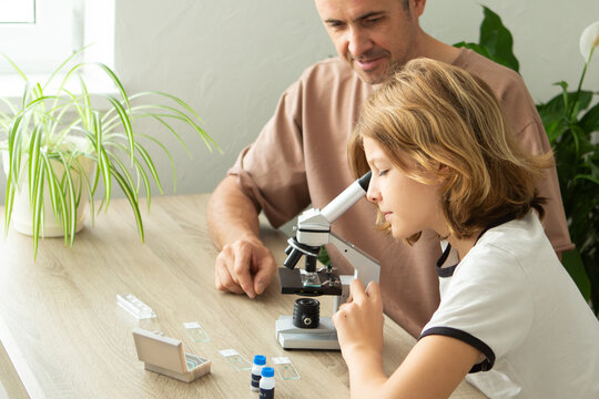 Exploring biology together at home with a microscope, father and daughter engage in learning activities
