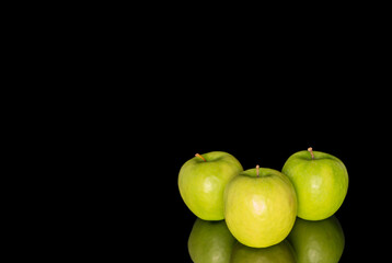 Juicy green apples isolated on black background, close-up.