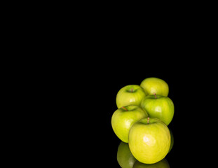 Juicy green apples isolated on black background, close-up.
