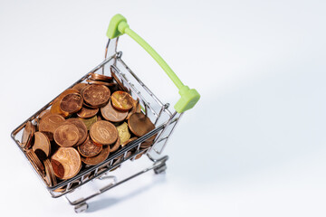 Mini shopping cart filled with euro cent coins, symbolizing savings, budgeting, expenses, commerce,...