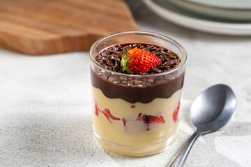 Dessert made with vanilla cream, strawberries and chocolate topping.